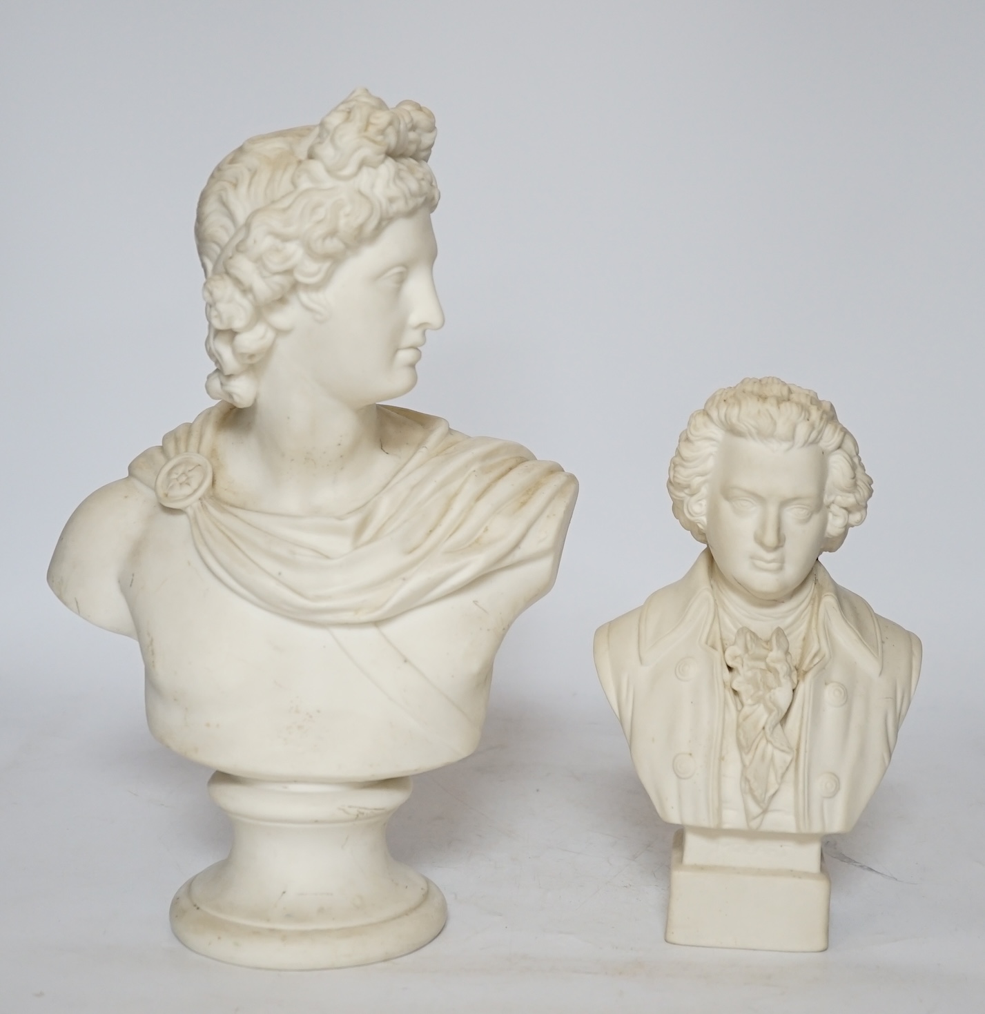 Two Continental biscuit porcelain busts, Mozart and Apollo, tallest 29cm